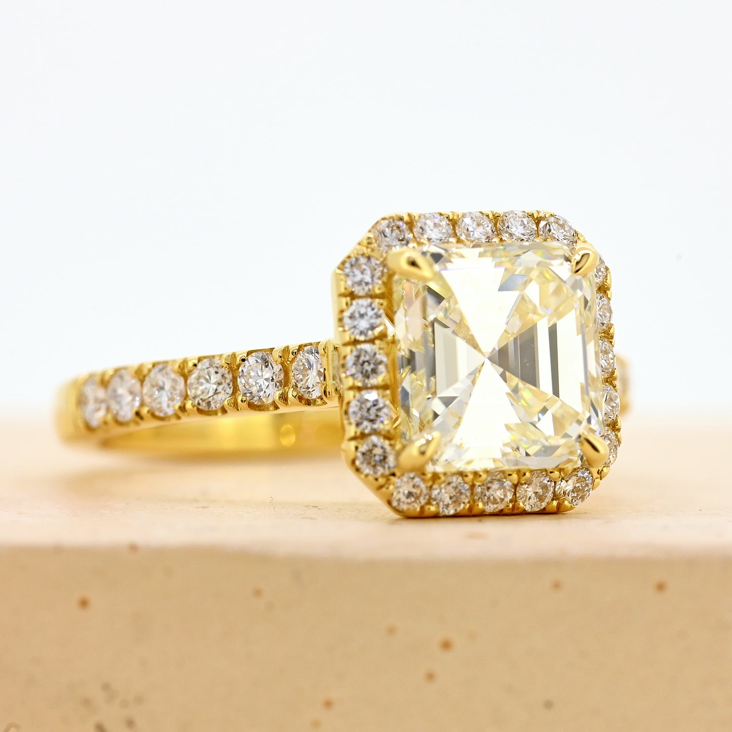 18ct asscher cut diamond ring, asscher diamond ring, asscher halo ring, asscher cut diamond ring with diamond shoulders, 18ct asscher halo ring with shoulder diamonds, 18ct yellow gold asscher cut diamond ring