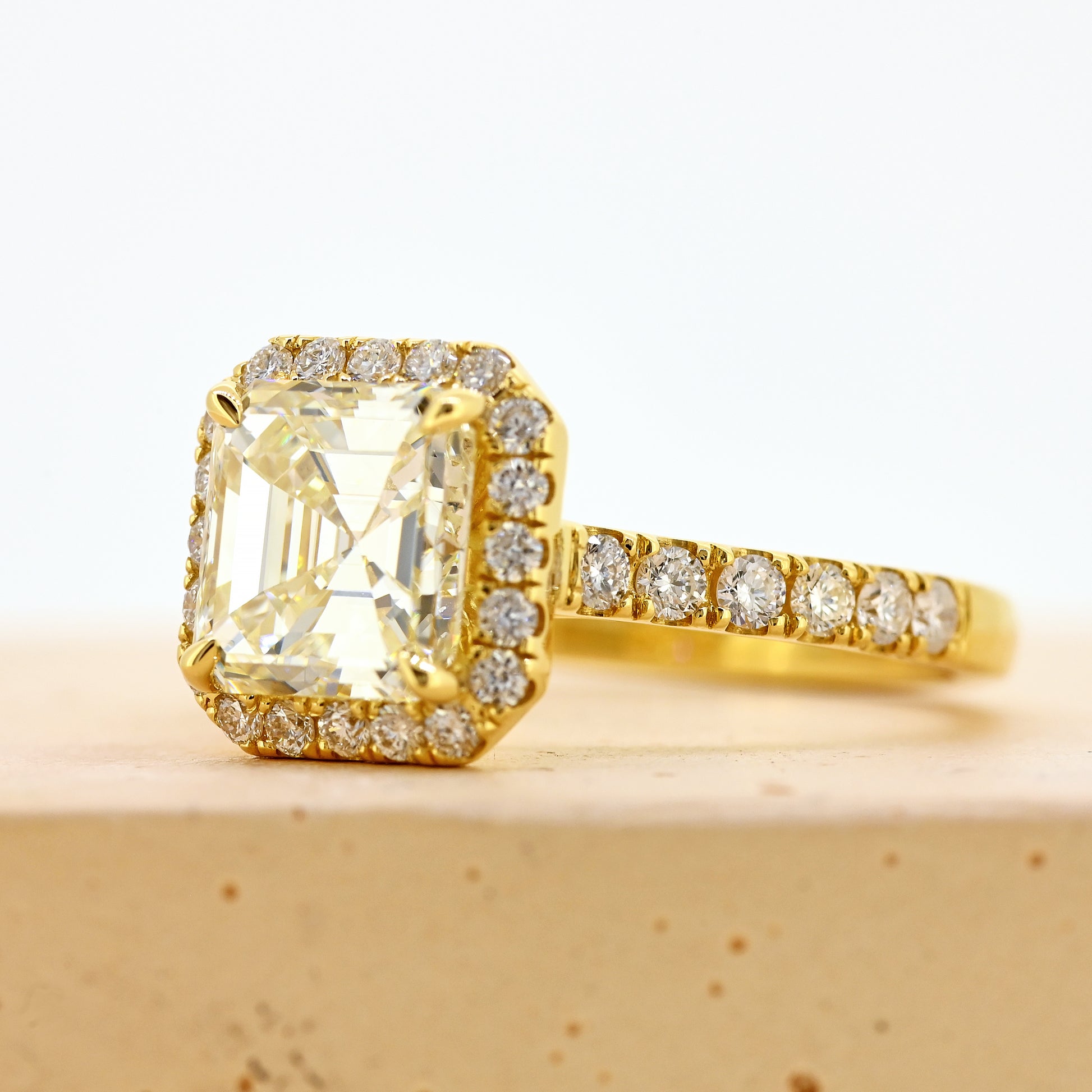 18ct asscher cut diamond ring, asscher diamond ring, asscher halo ring, asscher cut diamond ring with diamond shoulders, 18ct asscher halo ring with shoulder diamonds, 18ct yellow gold asscher cut diamond ring